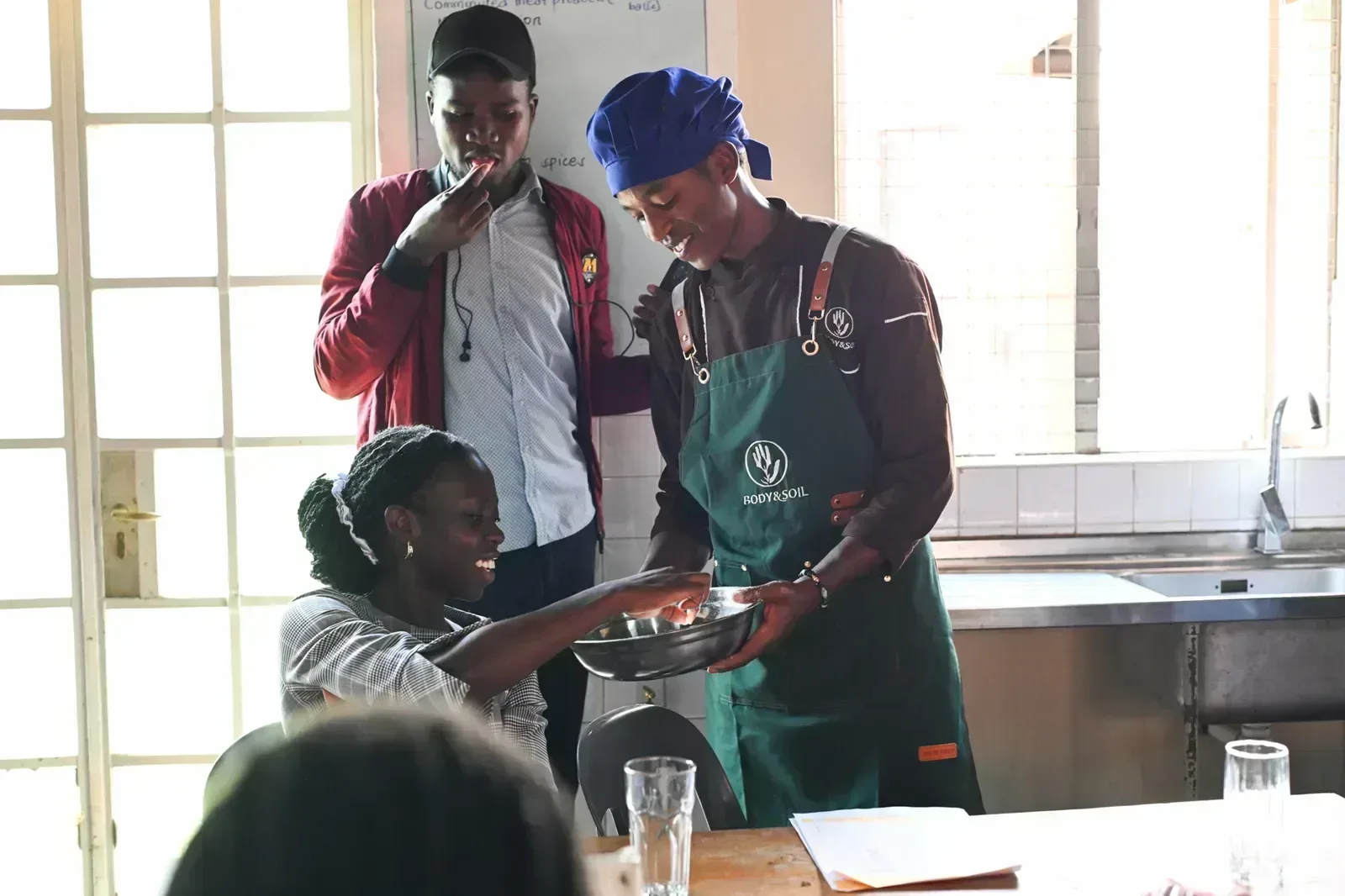 A BODY & SOIL chef shares a dish with students during the cooking session