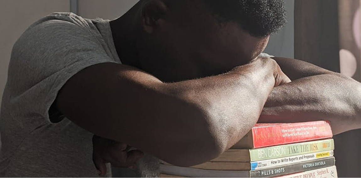 Student studying on campus with books